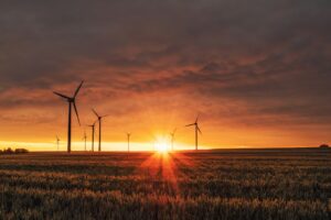 windmill on grass field during golden hour investimenti sostenibili